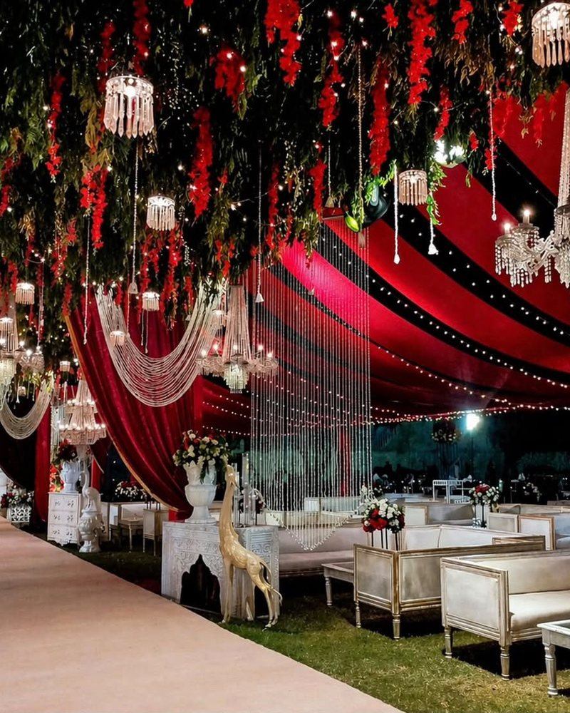 Baraat hall draped in red with crystal chandeliers by Wedding Alley