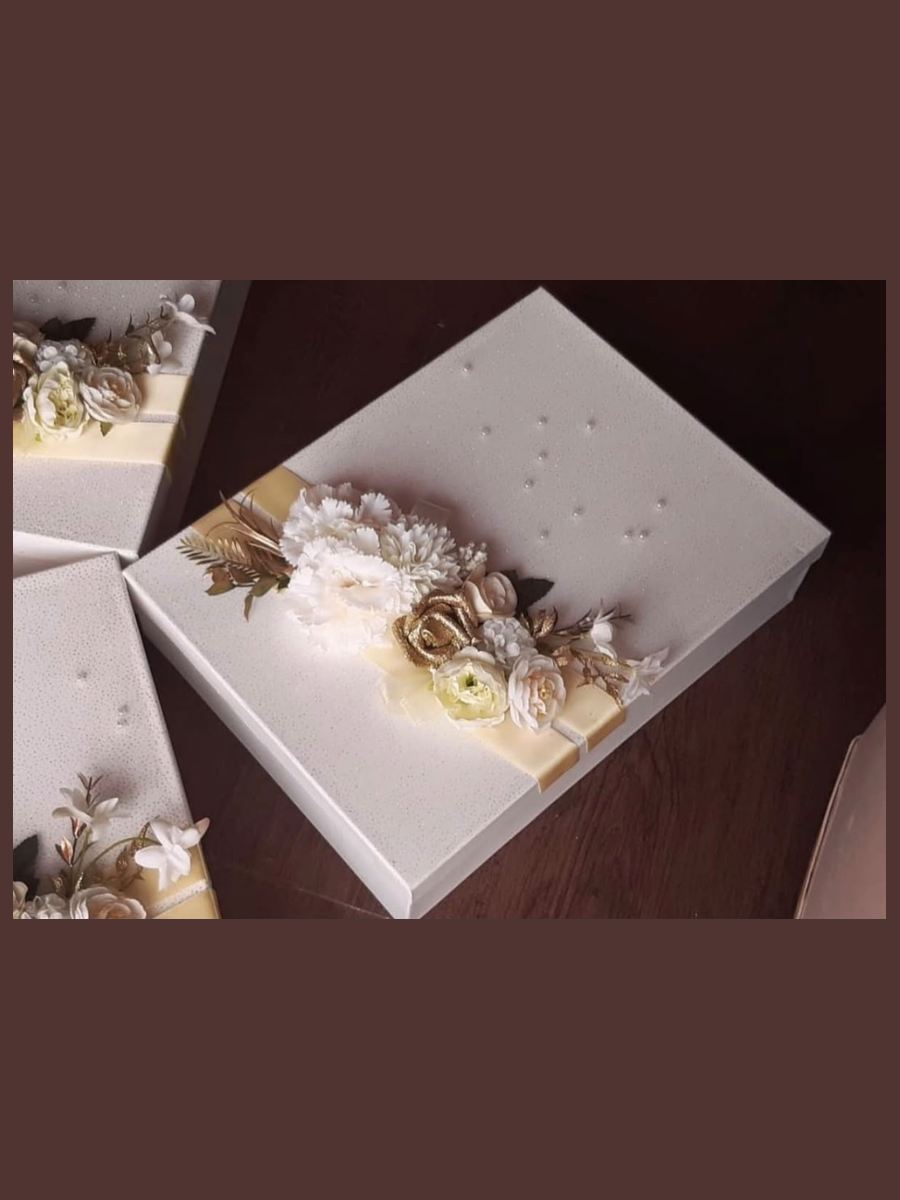 Custom wrapped gift boxes in ivory and gold with hand-set pearls by Wedding Alley